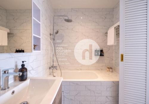 新加坡Hovoh Boutique Serviced Apartment的白色的浴室设有浴缸和水槽。