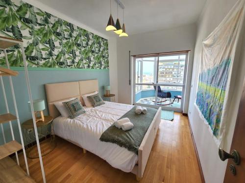 阿尔马达Cozy Apartment in central Almada w Swing Chairs的一间卧室设有一张大床和一个大窗户