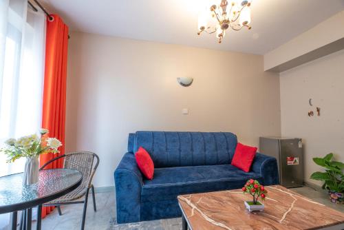 内罗毕The Bliss - Lovely 1 bedroom apartment located near TRM mall的客厅配有蓝色的沙发和桌子