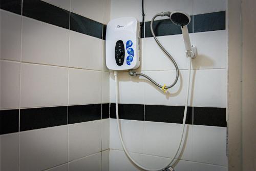 古晋Upspot Kuching Waterfront Premium Hostel的浴室设有淋浴,墙上配有吹风机