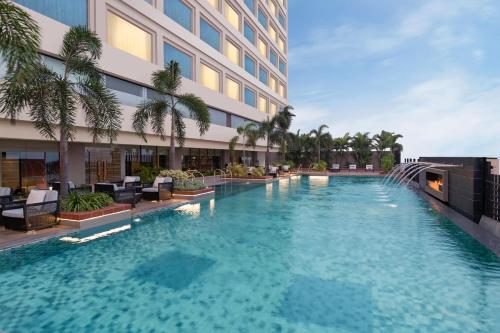 新德里新德里玛玉尔豪尔诺伊达皇冠假日酒店的大楼前的游泳池