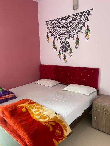 瓦拉纳西Banaras Guest House的一间卧室配有一张红色床头板的床