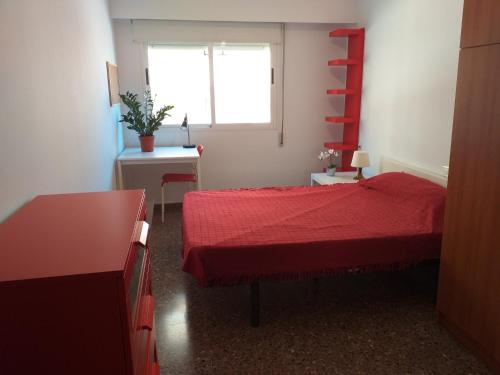 布尔哈索特PISO EN BURJASOT的一间卧室设有红色的床和窗户。