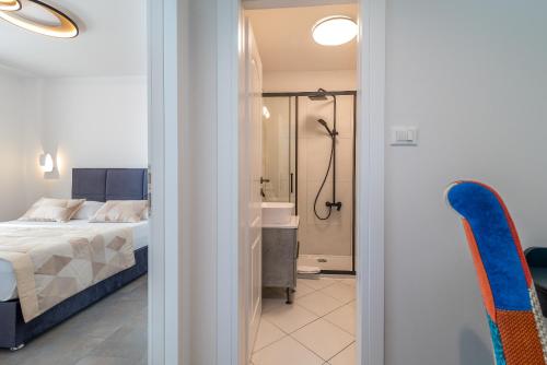 特罗吉尔利亚姆公寓的一间卧室配有一张床,浴室设有淋浴。