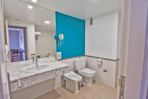 圣乌尔苏拉Coral La Quinta Park Suites的一间带水槽、卫生间和镜子的浴室