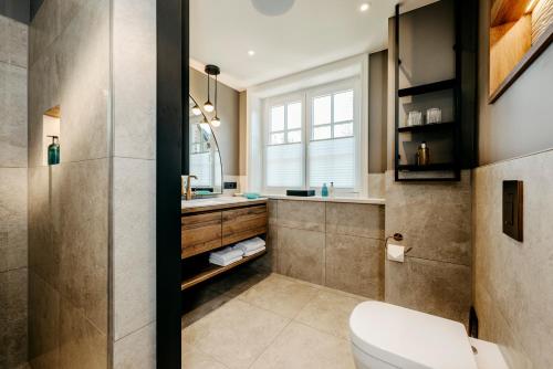 提努姆Relais & Châteaux Landhaus Stricker, Hotel des Jahres 2023的一间带卫生间和水槽的浴室