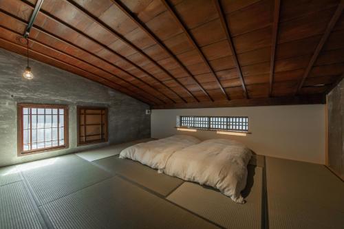 长滨市Hitoiki的一张位于带木制天花板的客房内的大床