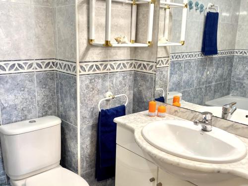 萨洛APARTBEACH LARIMAR MUY LUMINOSO y CLIMATIZADO的浴室配有白色卫生间和盥洗盆。