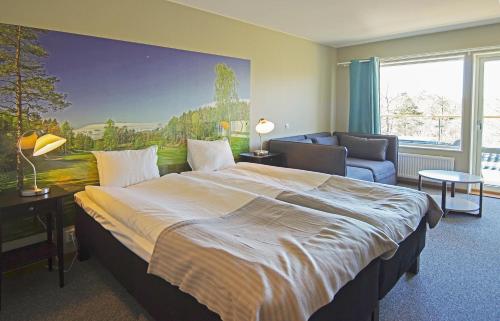亨尼博斯特兰德Sotenäs Golfhotell的一间卧室配有一张大床和一张沙发