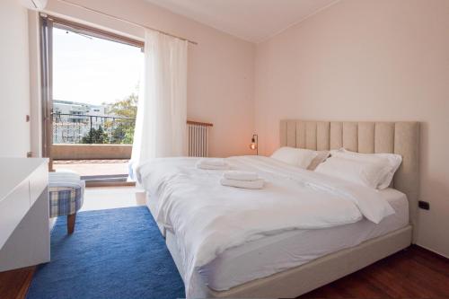 雅典Seaside Apartment with 3 bdrm and Shared Pool!的卧室设有一张大白色的床和大窗户