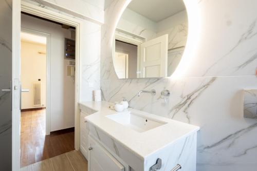 雅典Seaside Apartment with 3 bdrm and Shared Pool!的白色的浴室设有水槽和镜子