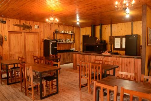 圣若阿金Pousada Querência Tarumã的一间带木桌椅的餐厅和一间厨房