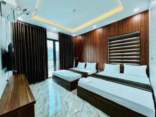 河静THÀNH HỒNG HOTEL的酒店客房设有两张床和电视。