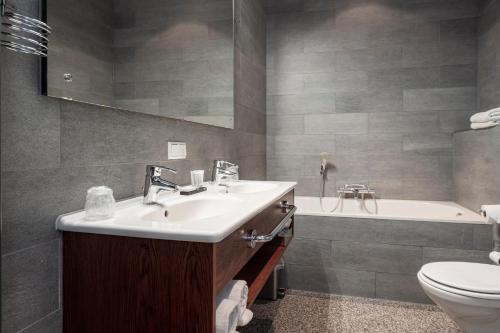 阿默斯福特海特科鲁斯特尔酒店的浴室配有盥洗盆、卫生间和浴缸。