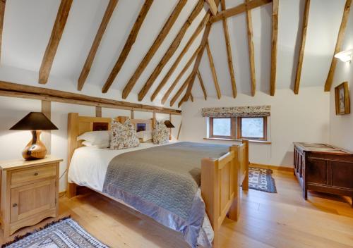 WestfieldBirdsong Barn的一间卧室设有一张大床,铺有木地板