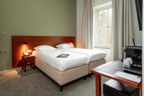 阿默斯福特海特科鲁斯特尔酒店的配有一张床和一张书桌的酒店客房