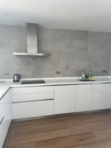 阿尔加德萨Modern duplex in Alcaidesa Links II的厨房配有白色橱柜和水槽