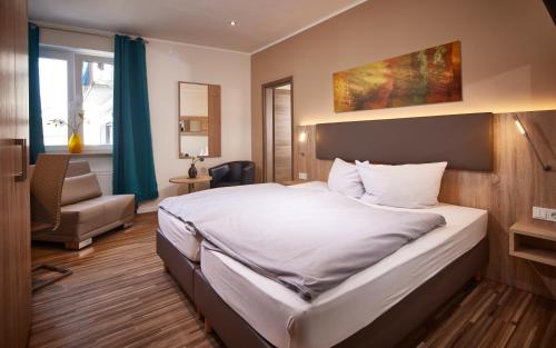 施魏希Hotel zum Stern的配有一张床和一把椅子的酒店客房