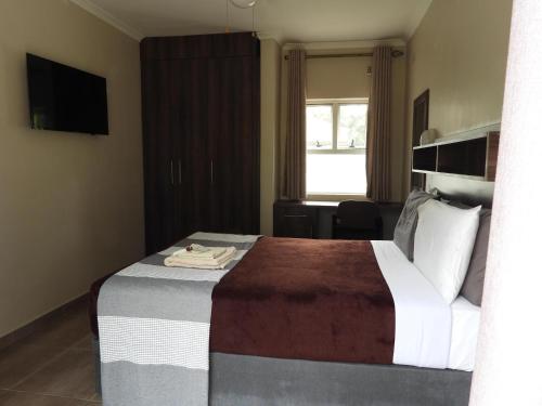哈拉雷2 Bed Apt with en-suite and kitchenette - 2066的酒店客房设有床和窗户。