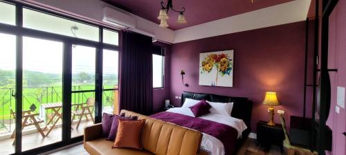 寄寓 Ji-Yu的一间带紫色墙壁和一张床的卧室以及一个阳台