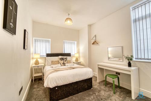 斯托桥Guest Homes - The Bell Apartment的一间卧室配有一张床和一张带镜子的书桌