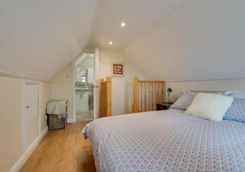 霍克赫斯特Rose Cottage的一间卧室配有一张带蓝色棉被的床