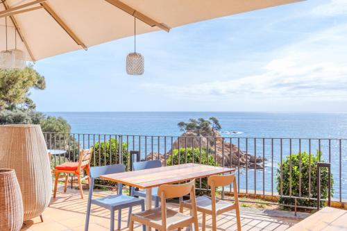 普拉加德阿罗Park Hotel San Jorge & Spa by Escampa Hotels的一个带桌椅的庭院和大海