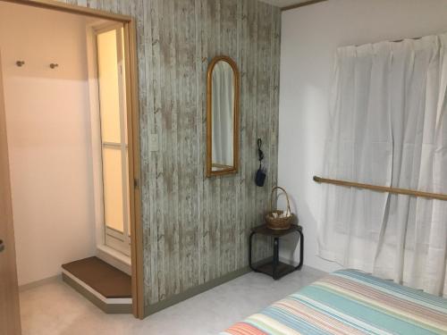 宫崎Accommodation Service B&B的一间卧室配有一张床、镜子和窗户