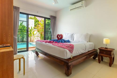 拉威海滩Thai-Themed 3br Boutique Villa by Intira Villas的一间卧室设有一张床和一个大窗户