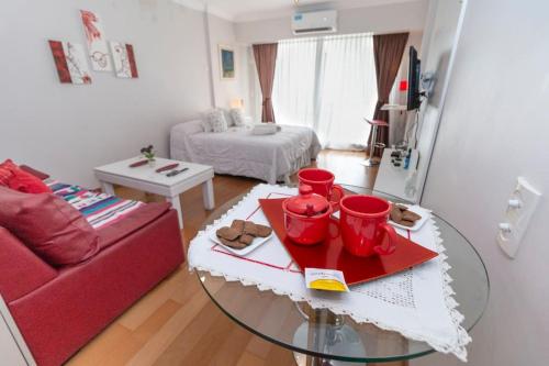 布宜诺斯艾利斯Departamento en Peña Recoleta MODERNO Y LUMINOSO的客厅配有桌子和红色沙发