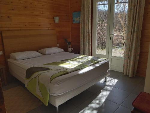Noyers-sur-JabronLa Prairie的一间带床的卧室,位于带窗户的房间内