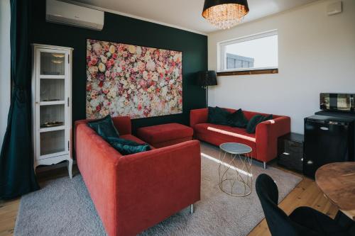 巴拉顿诺尔马迪Halacs Homes- Boutique cabins, Boutique Cabin的客厅配有两张红色的沙发和一幅画
