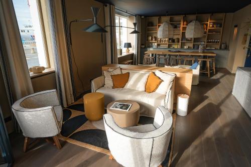 圣马洛Otonali Hôtel by Breizh Café的客厅配有沙发和两把椅子