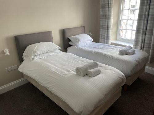 圣奥斯特尔康沃尔公爵酒店的卧室内的两张床和毛巾