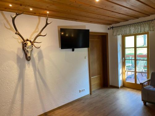 基姆湖畔贝尔瑙Ferienwohnung Jagdhäusl的墙上挂着鹿头的房间