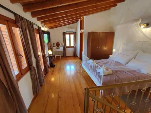 MourniaíNikόla's House的一间卧室设有一张大床,铺有木地板