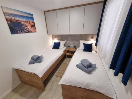 德拉格Premium mobile home SUN & JOY - Oaza Mira Camping的客房内的两张床和蓝色枕头