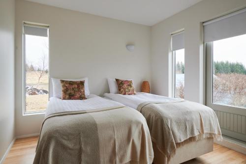 Sólheimar索海姆生态村旅馆的白色客房的两张床,设有窗户