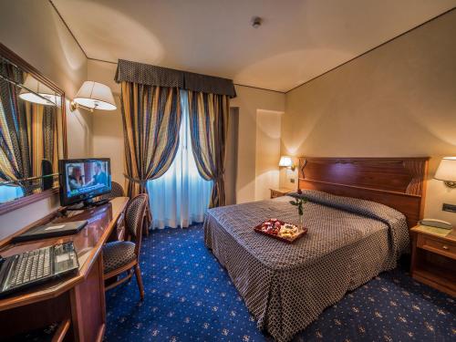 蒙特瓦尔基瓦尔达诺酒店的酒店客房配有一张床和一张带电脑的书桌