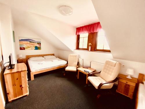 伊钦斯可姆维兹酒店的一间卧室配有一张床和两把椅子