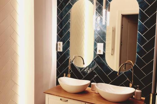 格但斯克Gdańsk Porto Apartments的浴室设有2个水槽和1个带镜子的台面