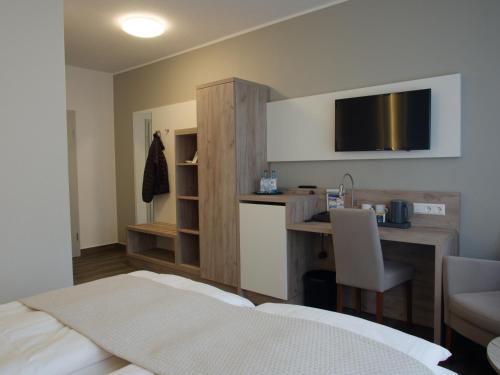 哈伦格瑞酒店的酒店客房配有一张床、一张书桌和一台电视。