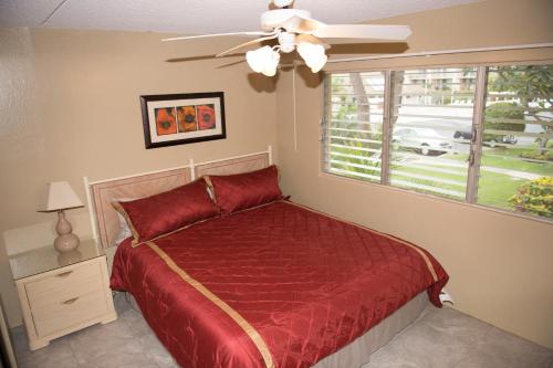 维雷亚基黑凯纳尼 - 毛伊岛威思塔公寓的一间卧室配有一张带吊扇和窗户的床。