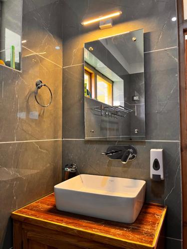 列城Ladakh Country Inn的浴室设有白色水槽和镜子
