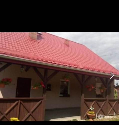 米科瓦伊基Studio Rodzinne ZACISZE的一座红色屋顶和围栏的房子