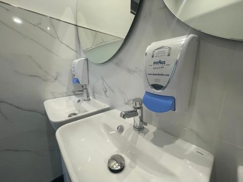 桑坦德Eurocity Hotel Santander Centro的墙上设有带水槽和肥皂机的浴室