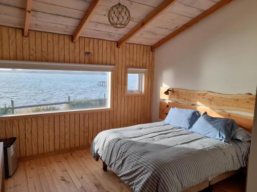 蒙特港Portal de la Patagonia Austral的一间卧室设有一张床和一个大窗户