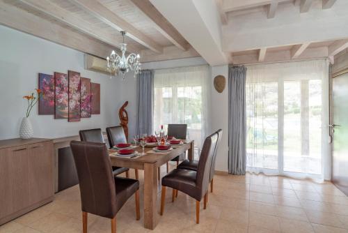 科林比亚Posidonia Luxury Villas Kolympia的一间带木桌和椅子的用餐室