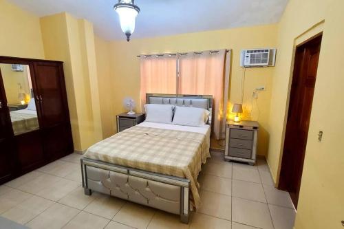 2 bedroom suite Peguyille的一间卧室设有床、两张桌子和一扇窗户