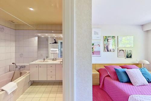 Basse-GoulaineLes Jardins de la Muse, piscine couverte, spa et fitness的一间带粉色沙发和浴缸的浴室